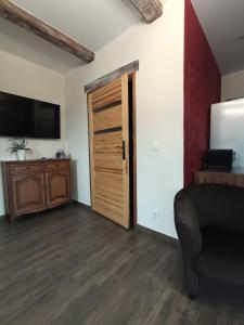 a room with a door and a tv and a couch at Gościniec Villa Romana in Piecki