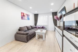 a living room with a couch and a table at Korsako apartamentai in Šiauliai