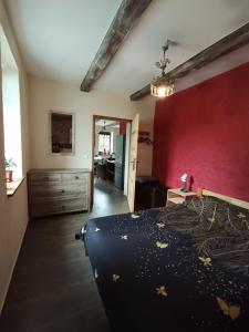 a bedroom with a bed and a red wall at Gościniec Villa Romana in Piecki