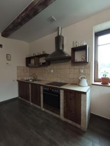 a kitchen with a stove and a sink and a window at Gościniec Villa Romana in Piecki