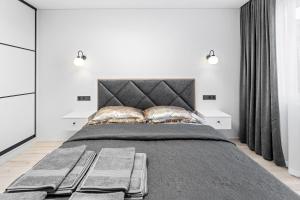 a bedroom with a large bed with two pillows at Korsako apartamentai in Šiauliai