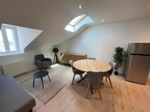 a living room with a table and chairs and a window at vannes évasion in Vannes