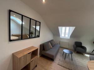 a living room with a couch and a mirror at vannes évasion in Vannes