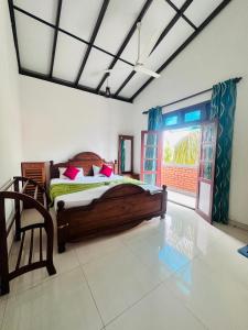 a bedroom with a wooden bed and a window at Panda House in Galle
