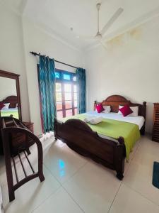 a bedroom with a large bed and a window at Panda House in Galle