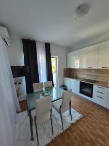 a kitchen with a glass table and chairs in a room at Apartmani Marković RAB in Palit +31 photos