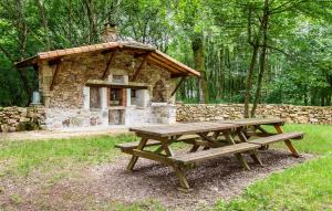 a picnic table in front of a stone house at Amazing Home In Lonnes With Heated Swimming Pool in Lonnes