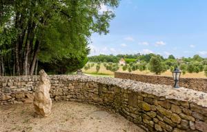 a stone wall with a lamp and a tree at Amazing Home In Lonnes With Heated Swimming Pool in Lonnes