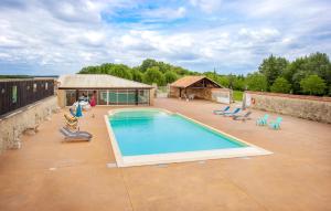 a swimming pool on a patio with chairs and a building at Amazing Home In Lonnes With Heated Swimming Pool in Lonnes +17 photos