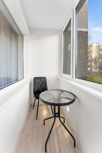 a table and a chair in a room with a window at Korsako apartamentai in Šiauliai