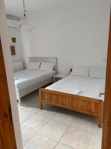 two beds sitting in a room withermottermottermott at Dimitra House Entire apartment with balcony and view in Pherrai
