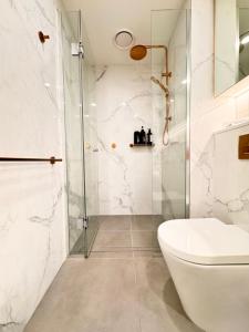 a bathroom with a shower and a white toilet at Skyline Views Premium 2B2B Free Parking Box Hill in Box Hill