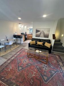 a living room with a couch and a table and a rug at Cozy Alpine A-Frame in Flagstaff