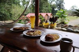 a wooden table with plates of food and drinks at LAS 7 CASCADAS Campground - Restaurant - Lodge in Cacaoal
