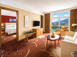 a hotel room with a bed and a living room at 泰安宝龙艺珺酒店 in Tai'an