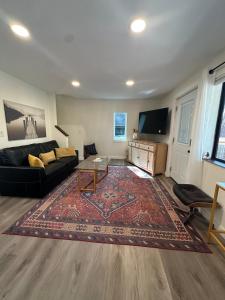 a living room with a black couch and a tv at Cozy Alpine A-Frame in Flagstaff