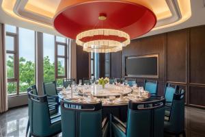 a conference room with a long table and chairs at Mövenpick Kaifeng West Lake in Kaifeng