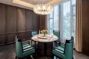a dining room with a table and chairs and a chandelier at Mövenpick Kaifeng West Lake in Kaifeng