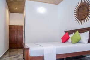 a room with a bed with colorful pillows on it at Breeze 12 Villa in Negombo +7 photos
