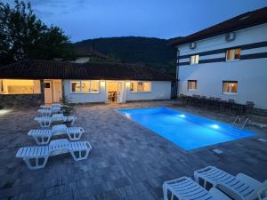 a villa with a swimming pool and lounge chairs at Althea Home & Wellness in Bihać