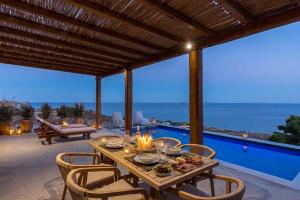 a table on a patio with a view of the ocean at Villa Lefko in Ano Syros