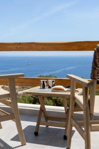 a table and chairs with a view of the ocean at Villa Lefko in Ano Syros