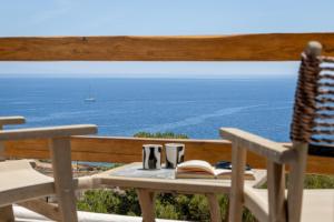 a table and chairs with a view of the ocean at Villa Lefko in Ano Syros +99 photos