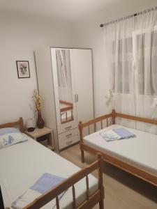 a bedroom with two beds and a mirror at Apartmani Ferri 1 in Vrbanj