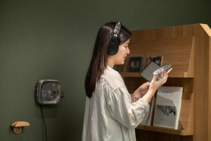 a woman wearing headphones looking at her cell phone at Oani in Taipei +17 photos