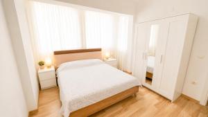 a white bedroom with a bed and a mirror at Fethiye Merkezde Lüx Daire in Fethiye