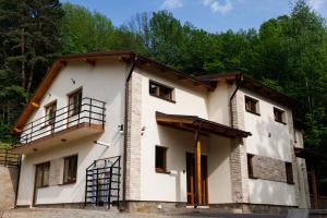 a large white building with a balcony at Vila MIHAI in Văliug