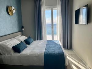a bedroom with a bed with a view of the ocean at Boutique Hotel Alassio in Alassio +5 photos