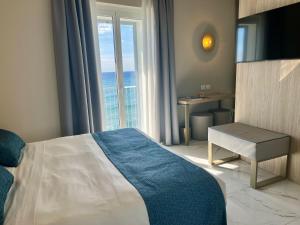 a hotel room with a bed and a large window at Boutique Hotel Alassio in Alassio