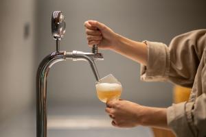 a person is drinking a beer from a faucet at Oani in Taipei