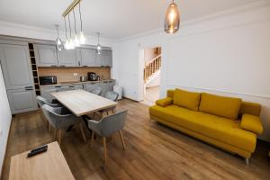 a living room with a yellow couch and a table at Vila MIHAI in Văliug