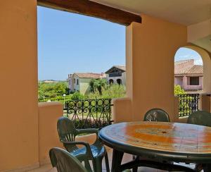 a patio with a table and chairs on a balcony at SardegnaSummer Il Borgo Porto San Paolo in Porto San Paolo