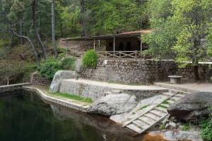 a house next to a body of water with a building at Villa Herrero in La Adrada