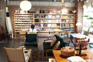 a room with chairs and tables and a shelf with books at 마음스테이 in Taesuha-dong