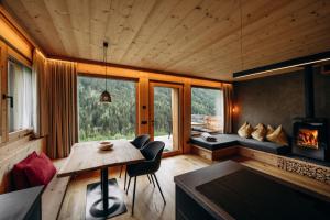 a living room with a table and a fireplace at Chalet Tschogerhof Tiers am Rosengarten Dolomiten in Tires