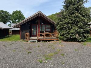 a small cabin with a porch and a tree at noordwind camping galsklint in Middelfart