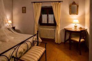 a bedroom with a bed and a table and a chair at Il Borghetto di Pedana- in Città di Castello +27 photos