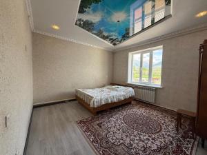a bedroom with a bed and a ceiling with a window at Tunduk House 14 in Bash-Kayyngdy