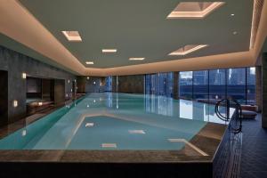 a swimming pool in a building with a large window at Alila Shanghai in Shanghai