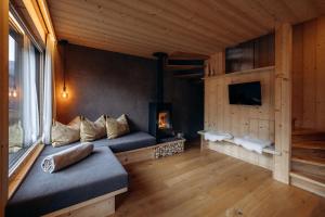 a living room with a couch and a tv at Chalet Tschogerhof Tiers am Rosengarten Dolomiten in Tires