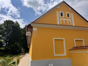 a yellow building with a window on the side of it at Ubytování U Mecha in Bečice