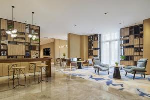 a lobby with chairs and tables in a library at Hyatt Place Shanghai Lingang in Zhenghai
