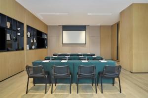 a conference room with a blue table and chairs at Hyatt Place Shanghai Lingang in Zhenghai