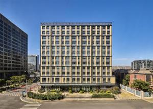 a tall white building with a lot of windows at Hyatt Place Shanghai Lingang in Zhenghai