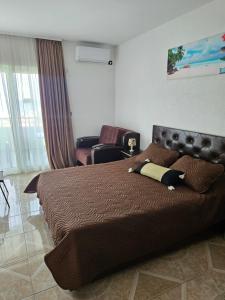 ein Schlafzimmer mit einem großen Bett und einem Stuhl in der Unterkunft Button Aparthotel in Dobra Voda + 20 Fotos