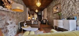 a living room with a couch and a stone wall at El Juacu in Llanes